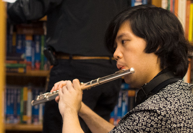 une musicien entrain de jouer un instrument de musique: la flute