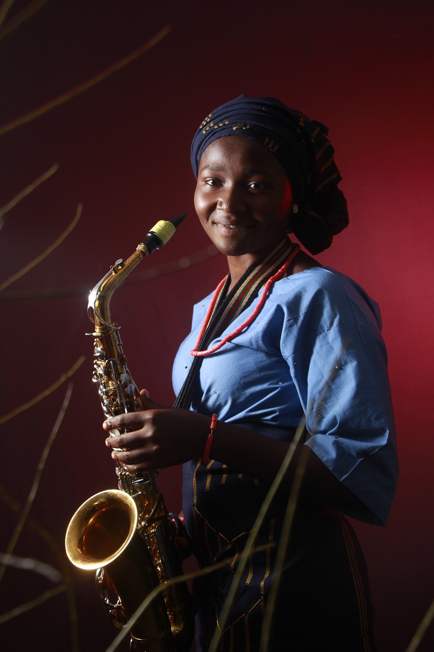 Une musicienne noir saxophoniste, elle prend son instrument entre ses mains et lance un sourire d'artiste en acoustique live